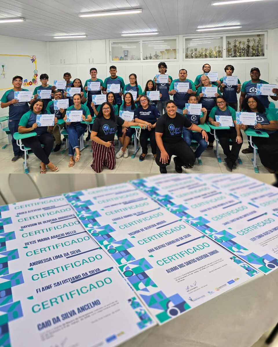 Turma completa exibindo certificados de conclusão de curso